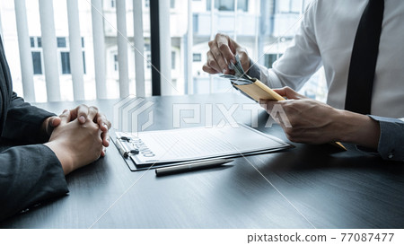 Dishonest cheating in illegal money, Businessman giving bribe money the form of dollar bills to while give success the deal to contract agreement, Bribery and corruption concept Dishonest cheating in illegal money, Businessman giving bribe money the form of dollar bills to while give success the deal to contract agreement, Bribery and corruption concept 77087477