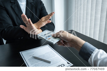 Business woman refusing and don't receive money banknote in envelope offer from business people to accept agreement contract of investment deal Business woman refusing and don't receive money banknote in envelope offer from business people to accept agreement contract of investment deal 77087489
