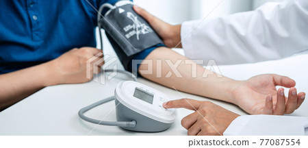 Doctor is checking the patient blood pressure in his hospital office Doctor is checking the patient blood pressure in his hospital office 77087554