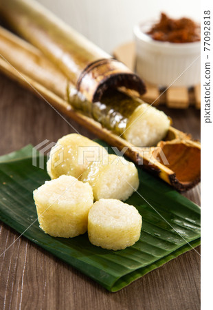 Glutinous rice is wrapped with lerek or banana leaf encased in bamboo culm and cooked in open fire / Lemang / A must have in every traditional Malay household, eaten with beef or chicken rendang 77092818