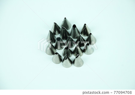 Sets of cream piping nozzles made from stainless steel isolated on white background. It is used to decorate cakes using cream. Sets of cream piping nozzles made from stainless steel isolated on white background. It is used to decorate cakes using cream. 77094708