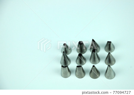 Sets of cream piping nozzles made from stainless steel isolated on white background. It is used to decorate cakes using cream. Sets of cream piping nozzles made from stainless steel isolated on white background. It is used to decorate cakes using cream. 77094727