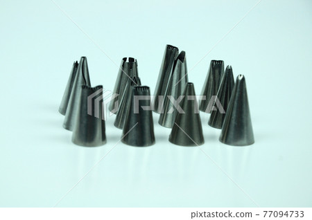 Sets of cream piping nozzles made from stainless steel isolated on white background. It is used to decorate cakes using cream. Sets of cream piping nozzles made from stainless steel isolated on white background. It is used to decorate cakes using cream. 77094733