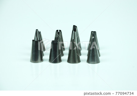 Sets of cream piping nozzles made from stainless steel isolated on white background. It is used to decorate cakes using cream. Sets of cream piping nozzles made from stainless steel isolated on white background. It is used to decorate cakes using cream. 77094734