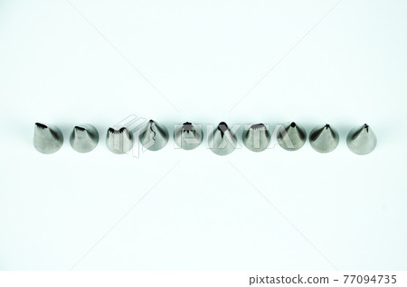 Sets of cream piping nozzles made from stainless steel isolated on white background. It is used to decorate cakes using cream. Sets of cream piping nozzles made from stainless steel isolated on white background. It is used to decorate cakes using cream. 77094735