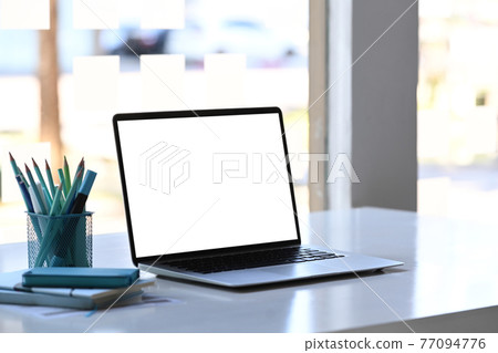 A laptop computer stationery and notebook on creative designer workspace. Blank screen for graphics display montage. A laptop computer stationery and notebook on creative designer workspace. Blank screen for graphics display montage. 77094776
