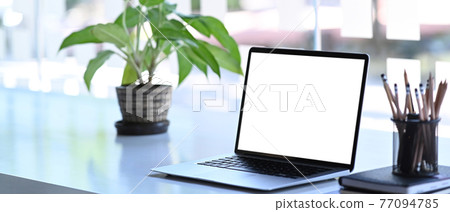 Creative workspace with laptop computer, pot plant, stationery and notebook on white desk. Blank screen for graphics display montage. Creative workspace with laptop computer, pot plant, stationery and notebook on white desk. Blank screen for graphics display montage. 77094785