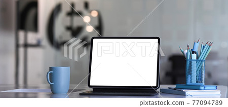 Designer workspace with tablet computer, coffee cup, stationery and notebook on white desk. Blank screen for graphics display montage. Designer workspace with tablet computer, coffee cup, stationery and notebook on white desk. Blank screen for graphics display montage. 77094789