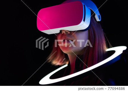 Woman is using virtual reality headset. 77094886