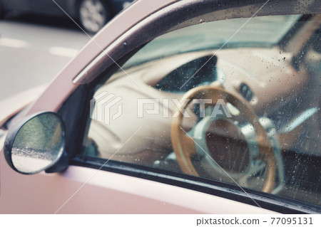 Fragment of the driver window and rear view mirrors covered with rain drops Fragment of the driver window and rear view mirrors covered with rain drops 77095131