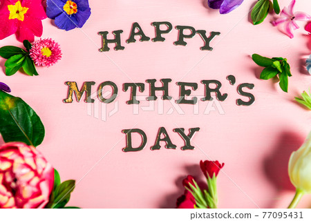 Happy Mothers Day letters with different spring flowers around them 77095431
