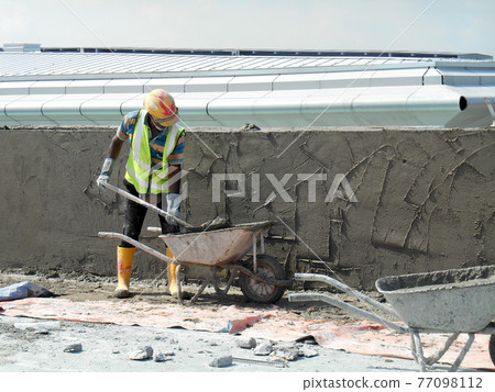 JASIN, MALAYSIA -JANUARY 14, 2017: Construction workers plastering building wall and beam using cement plaster mix of cement and sand at the construction site in Jasin, Malaysia 77098112