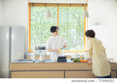 Holiday couple in the kitchen Holiday couple in the kitchen 77099201