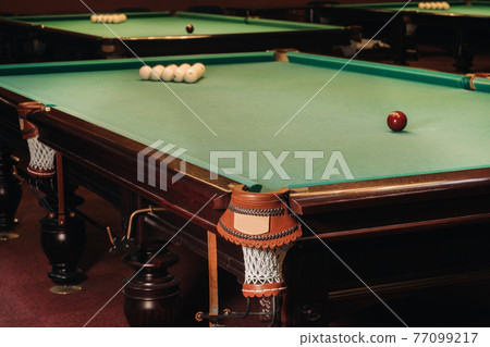 Billiard table with green surface and balls in the billiard club.Pool Game Billiard table with green surface and balls in the billiard club.Pool Game 77099217