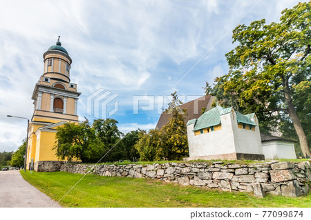 Hollola, Finland - 9 September 2019: Bell tower of old medieval stone church of St. Mary in Hollola, Finland 77099874