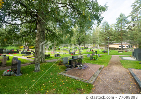 Hollola, Finland - 9 September 2019: Cemetery on the yard of old medieval stone church of St. Mary in Hollola, Finland 77099898