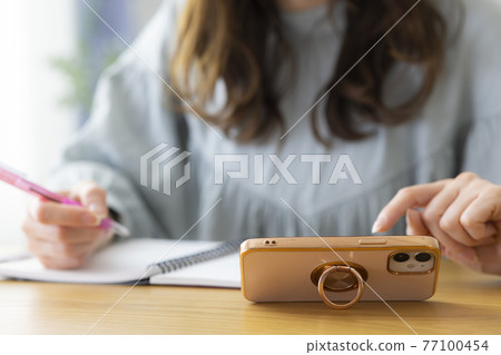 A woman studying in the living room 77100454