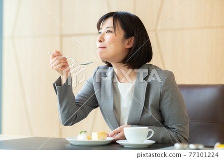 Working woman eating cake Working woman eating cake 77101224