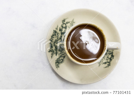 Overhead view on serving of classic retro cup of coffee at kopitiam or old coffee shop Overhead view on serving of classic retro cup of coffee at kopitiam or old coffee shop 77101431
