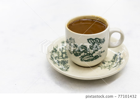 Serving of classic retro cup of coffee at kopitiam or old coffee shop Serving of classic retro cup of coffee at kopitiam or old coffee shop 77101432