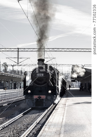 Kouvola, Finland - April 18, 2019: Old steam train Ukko-Pekka is leaving the station at morning. Kouvola, Finland - April 18, 2019: Old steam train Ukko-Pekka is leaving the station at morning. 77102316