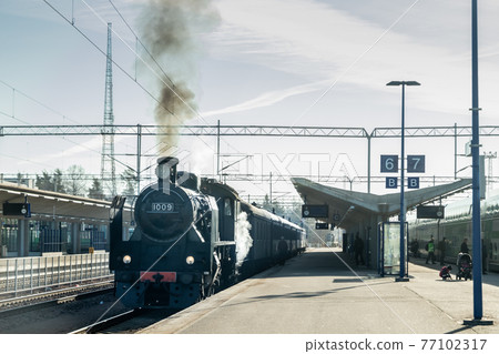 Kouvola, Finland - April 18, 2019: Old steam train Ukko-Pekka is leaving the station at morning. 77102317