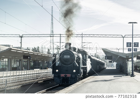 Kouvola, Finland - April 18, 2019: Old steam train Ukko-Pekka is leaving the station at morning. Kouvola, Finland - April 18, 2019: Old steam train Ukko-Pekka is leaving the station at morning. 77102318