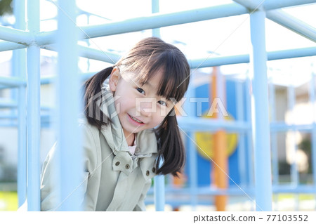5-year-old girl playing in the park jungle gym 77103552