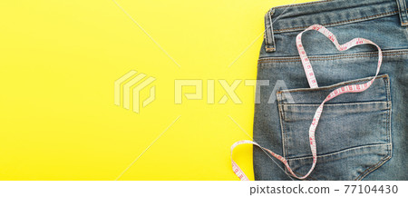 blue jeans with measure tape in pocket in form of a heart. concept of healthy lifestyle and diet with love to your body 77104430