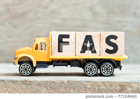 Toy truck hold alphabet letter block in word FAS (Abbreviation of Fetal alcohol syndrome, Free alongside or Financial accounting standards) on wood background 77104660
