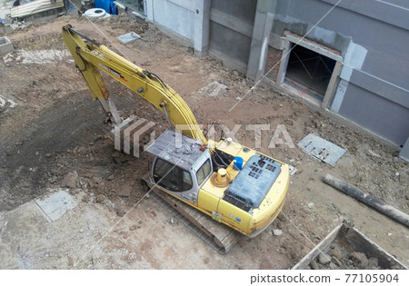 MALACCA, MALAYSIA -FEBRUARY 16, 2017: Excavators machine is a heavy construction machine used excavated soil during construction. Powered by a long hydraulic arm with the bucket. MALACCA, MALAYSIA -FEBRUARY 16, 2017: Excavators machine is a heavy construction machine used excavated soil during construction. Powered by a long hydraulic arm with the bucket. 77105904