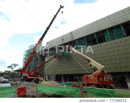 MALACCA, MALAYSIA -FEBRUARY 16, 2017: Construction workers standing in the mobile crane bucket while working at a high level in the construction site. The bucket movement control by the workers themse MALACCA, MALAYSIA -FEBRUARY 16, 2017: Construction workers standing in the mobile crane bucket while working at a high level in the construction site. The bucket movement control by the workers themse 77106012