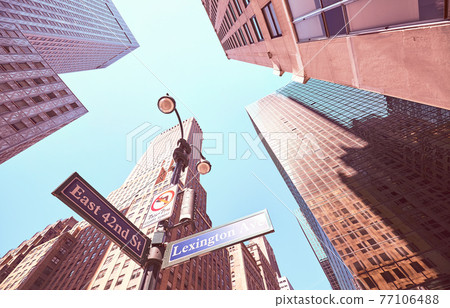 Looking up at Lexington Avenue and East 42nd Street signs in Manhattan, color toned picture, New York City, USA. 77106488