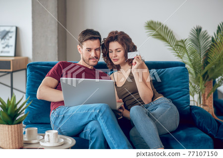 Young couple choosing something for buying online Young couple choosing something for buying online 77107150