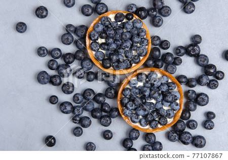 Delicious desserts of blueberry mini tart with fresh berries. Flat lay Delicious desserts of blueberry mini tart with fresh berries. Flat lay 77107867