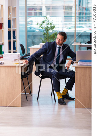 Young male employee working in the office Young male employee working in the office 77109039