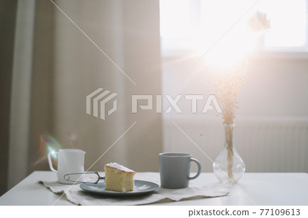 Morning breakfast with a piece of fresh homemade cake, pitcher and cup of coffee on a table Morning breakfast with a piece of fresh homemade cake, pitcher and cup of coffee on a table 77109613