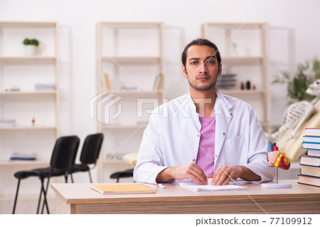 Young male doctor student cardiologist sitting in the classroom Young male doctor student cardiologist sitting in the classroom 77109912