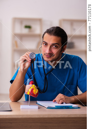 Young male doctor cardiologist working in the clinic 77110178