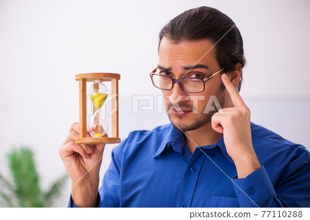 Young male teacher in time management concept 77110288
