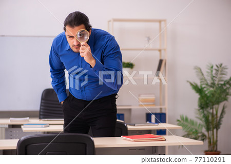Young male teacher in front of whiteboard Young male teacher in front of whiteboard 77110291