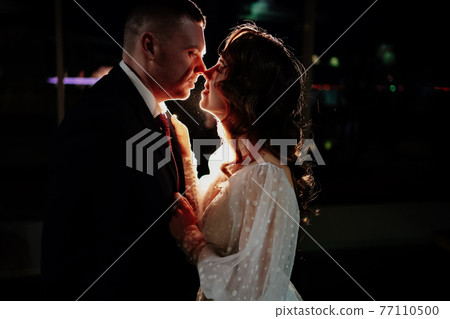 profiles of the bride and groom in the dark in a counter-light. 77110500