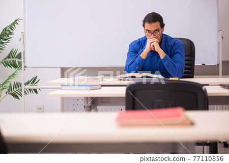 Young male teacher in front of whiteboard 77110856