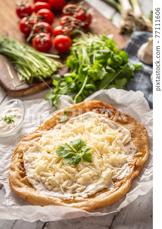 Precisely prepared hungarian traditional langos Precisely prepared hungarian traditional langos 77111606