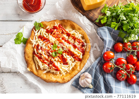 Tasty deep-fried langos served on baking paper 77111619