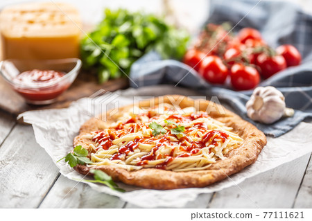 Tasty deep-fried langos served on baking paper 77111621