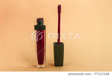 Liquid lipstick open tube and applicator wand isolated on white backgrpund. Hot pink lip gloss Liquid lipstick open tube and applicator wand isolated on white backgrpund. Hot pink lip gloss 77112146