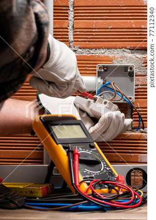 Electrician at work on a residential electrical system. Electricity. 77112340