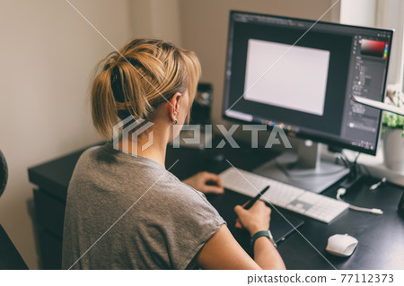 Woman drawing on graphic tablet Woman drawing on graphic tablet 77112373
