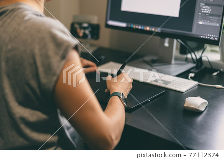 Woman drawing on graphic tablet Woman drawing on graphic tablet 77112374